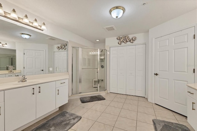 bathroom with vanity, tile patterned floors, and a shower with door