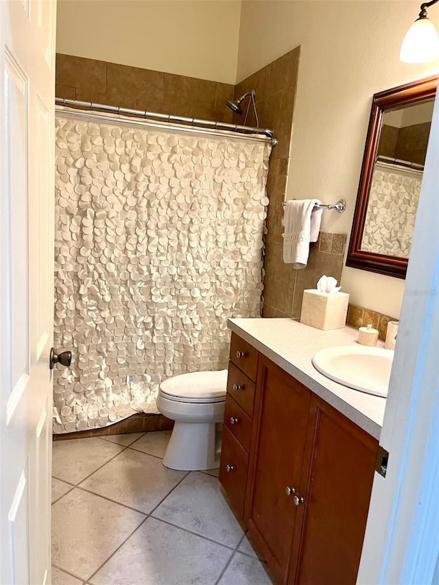 bathroom with toilet, tile patterned floors, and vanity