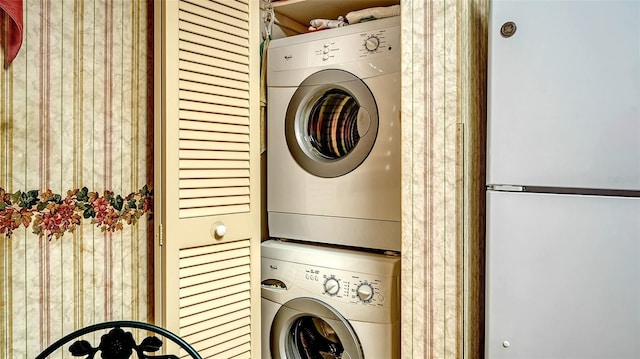 clothes washing area featuring stacked washing maching and dryer