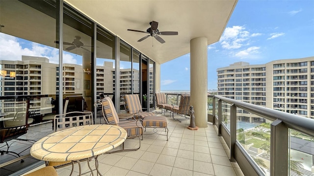 balcony with ceiling fan and a water view