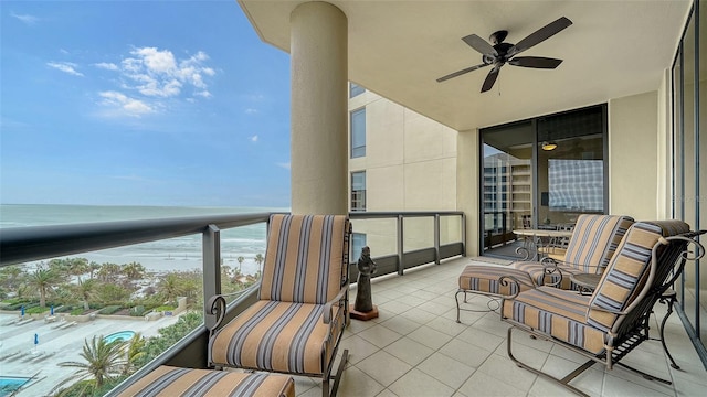 balcony with ceiling fan and a water view