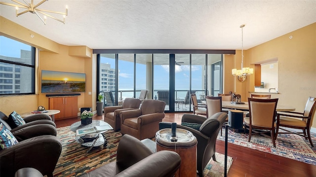 living room with a wall of windows, an inviting chandelier, and dark wood-type flooring