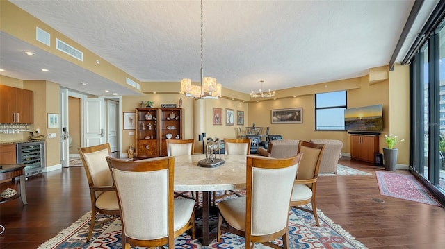 dining space with a textured ceiling, dark hardwood / wood-style floors, a notable chandelier, and wine cooler