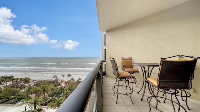 balcony featuring a water view and a view of the beach