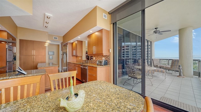 interior space with ceiling fan, decorative backsplash, light stone countertops, floor to ceiling windows, and appliances with stainless steel finishes