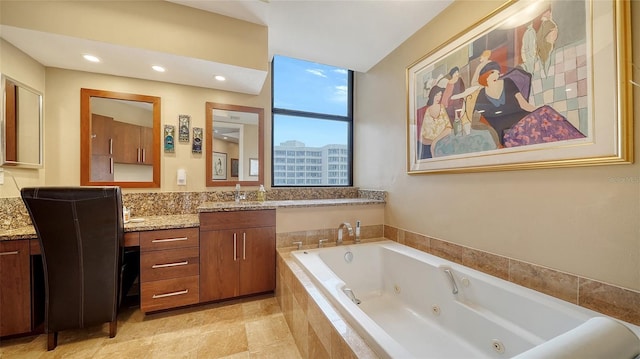 bathroom featuring a relaxing tiled tub and vanity