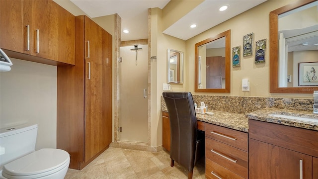 bathroom featuring toilet, an enclosed shower, and vanity