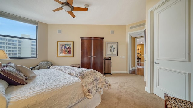 bedroom with ceiling fan and light carpet