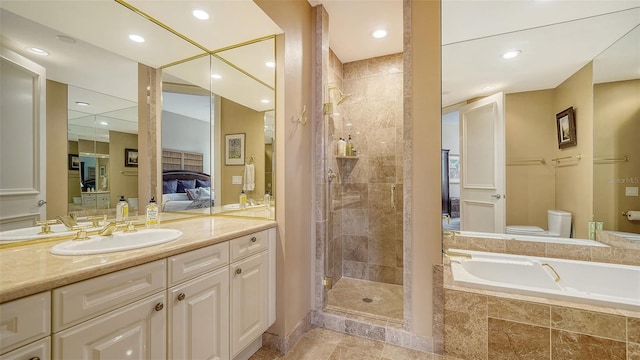 full bathroom featuring toilet, vanity, and independent shower and bath