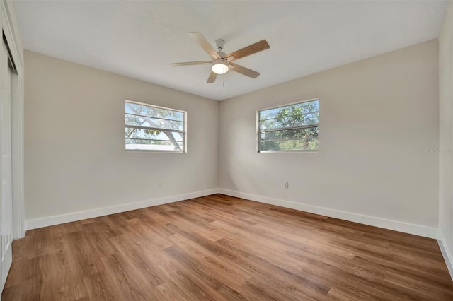 empty room featuring light wood-type flooring, ceiling fan, and a wealth of natural light