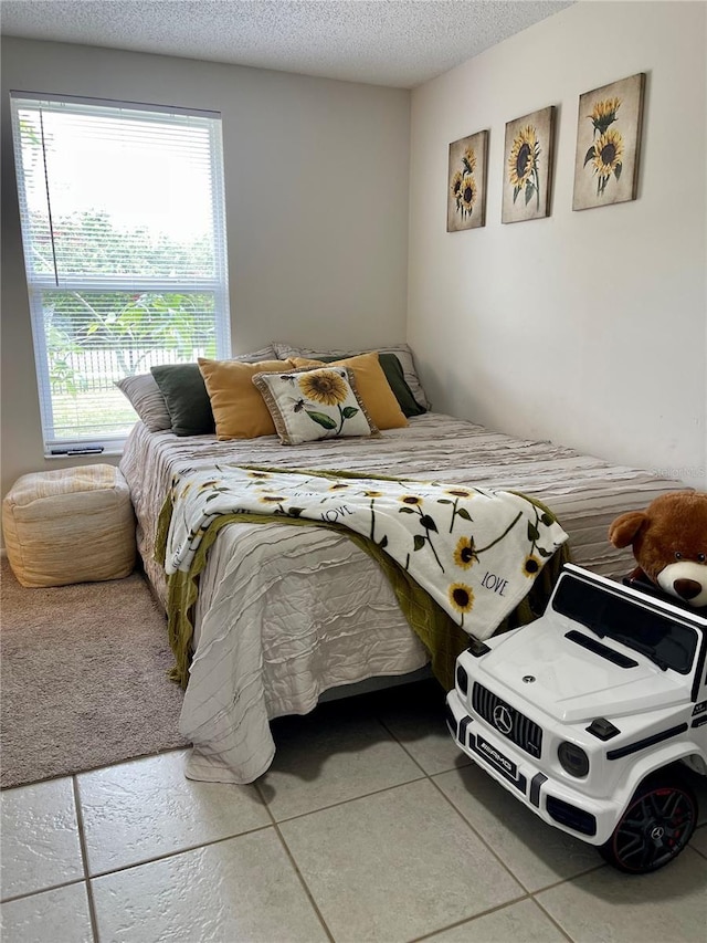 bedroom featuring a textured ceiling and tile patterned floors