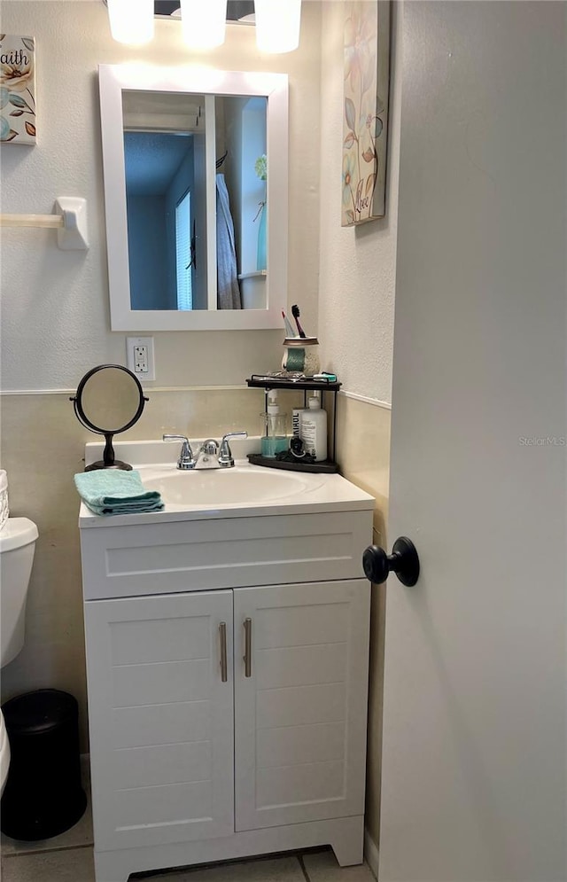 bathroom featuring toilet, tile patterned flooring, and vanity