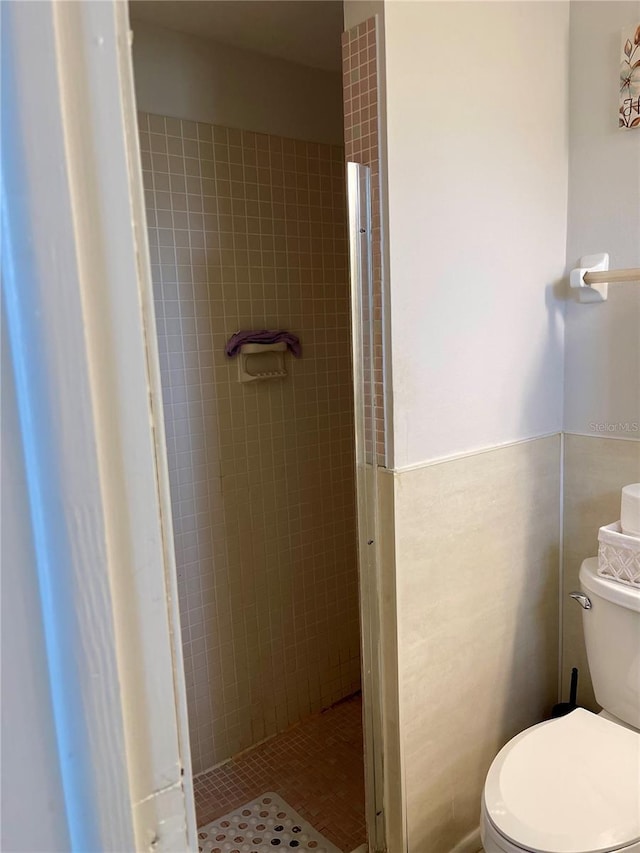 bathroom with toilet and tiled shower