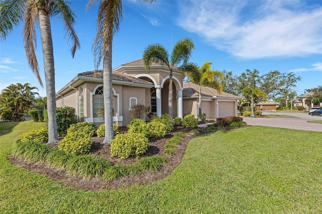 mediterranean / spanish house with a garage and a front yard