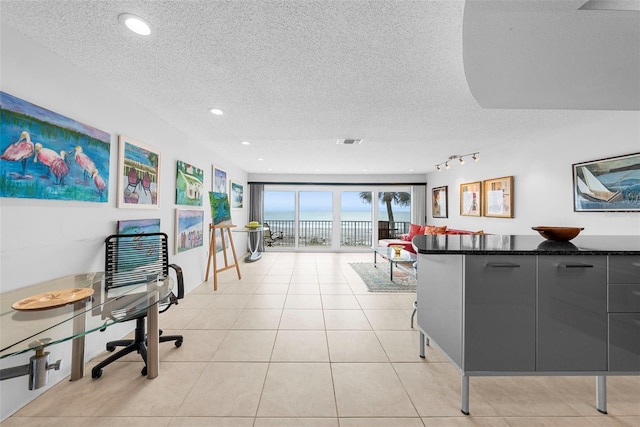 interior space with light tile patterned floors, track lighting, and a textured ceiling