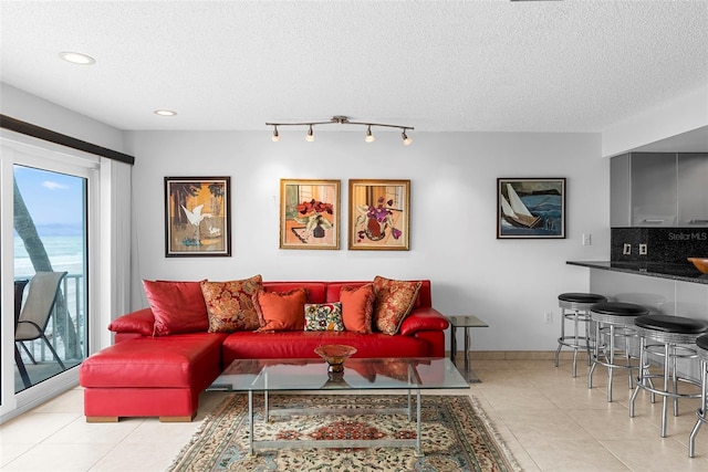 tiled living room with a textured ceiling and rail lighting