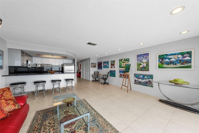 tiled living room featuring a textured ceiling