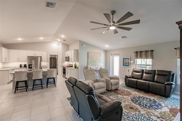 living room featuring vaulted ceiling, ceiling fan, and light tile patterned floors