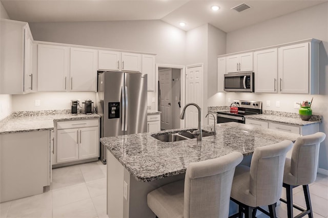 kitchen featuring sink, white cabinets, stainless steel appliances, and a kitchen island with sink