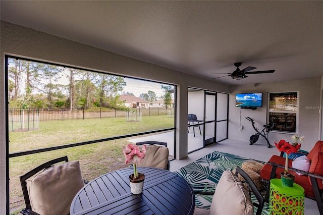 sunroom / solarium featuring ceiling fan