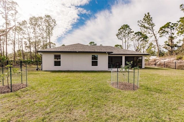 rear view of house with a yard and a sunroom