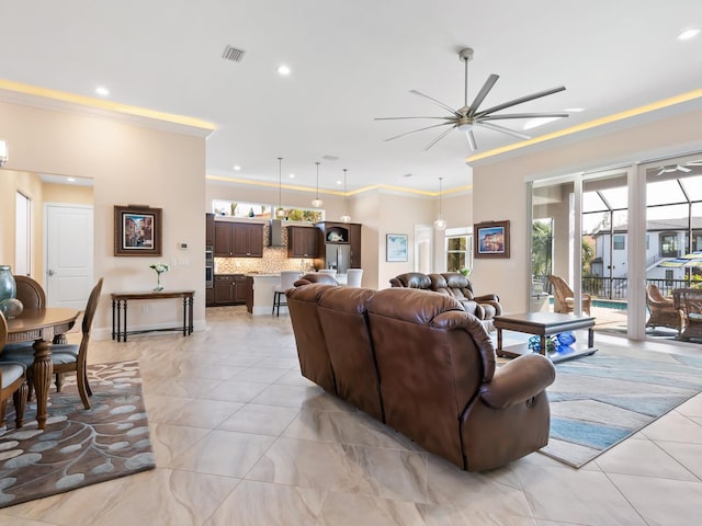 living room with ceiling fan and crown molding