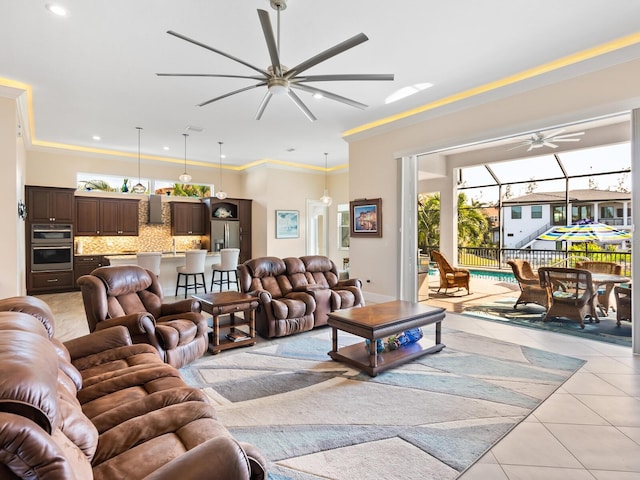 living room featuring sink, ceiling fan, crown molding, and light tile patterned floors