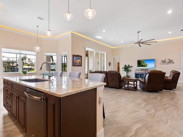 kitchen featuring decorative light fixtures, sink, light stone counters, and dishwasher