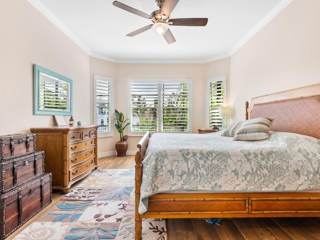 bedroom with light wood-type flooring, ceiling fan, and ornamental molding