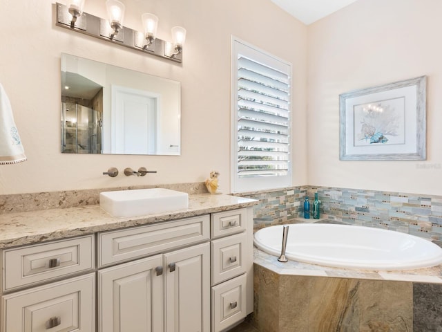 bathroom featuring tiled tub and vanity