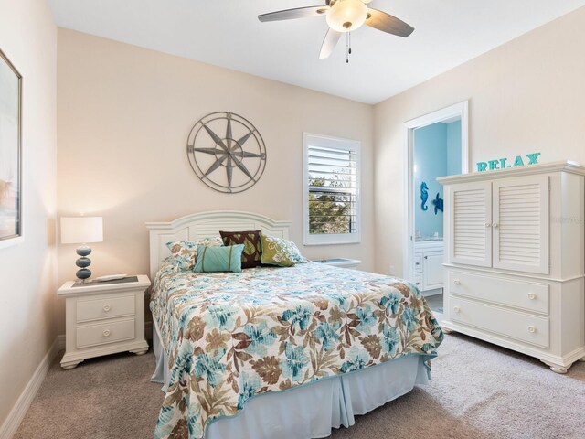 carpeted bedroom featuring ceiling fan and ensuite bath