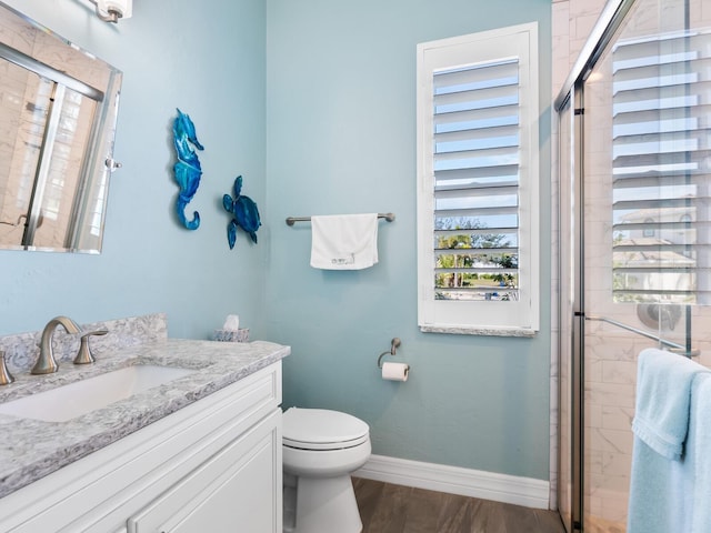 bathroom featuring wood-type flooring, toilet, an enclosed shower, and vanity