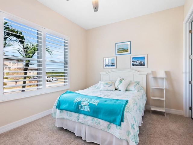 bedroom featuring ceiling fan, multiple windows, and carpet flooring