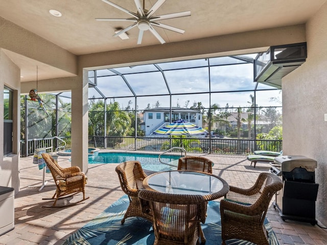 view of patio / terrace featuring ceiling fan and glass enclosure