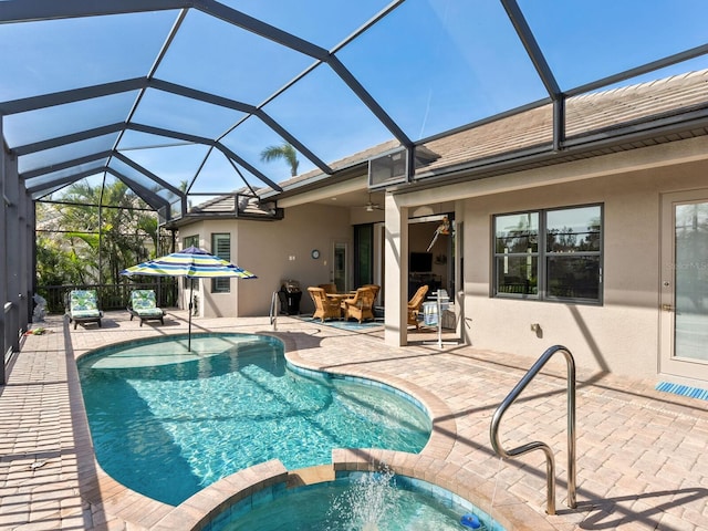 view of pool featuring an in ground hot tub, glass enclosure, an outdoor hangout area, and a patio