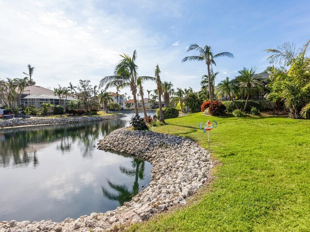 surrounding community with a lawn and a water view