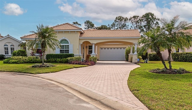 mediterranean / spanish home featuring a front yard and a garage