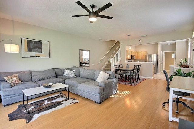 living room with light hardwood / wood-style floors and ceiling fan