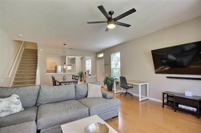 living room with hardwood / wood-style floors, a textured ceiling, and ceiling fan