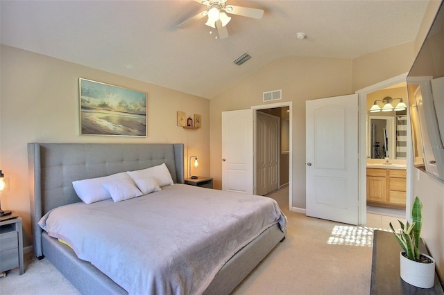 carpeted bedroom featuring ceiling fan, ensuite bathroom, and lofted ceiling