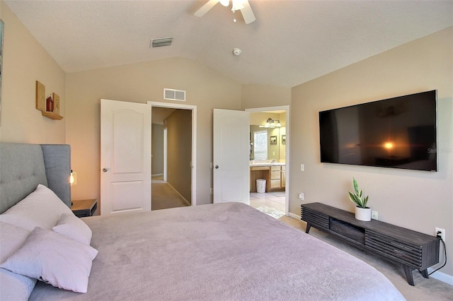 carpeted bedroom featuring ceiling fan, connected bathroom, and vaulted ceiling