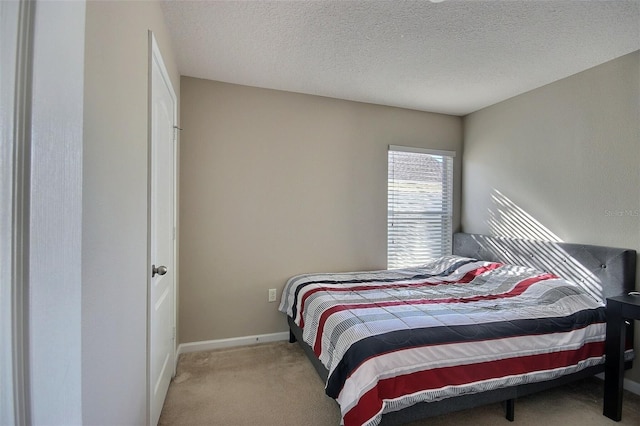 bedroom with a textured ceiling and light carpet