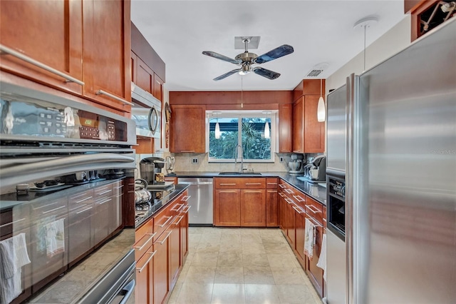 kitchen with backsplash, sink, ceiling fan, and appliances with stainless steel finishes