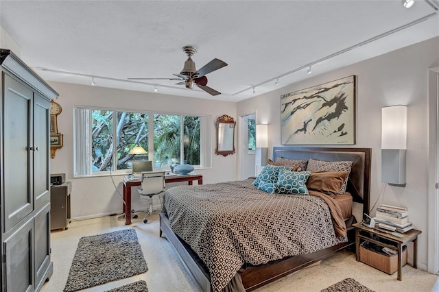 bedroom with ceiling fan, rail lighting, and a textured ceiling