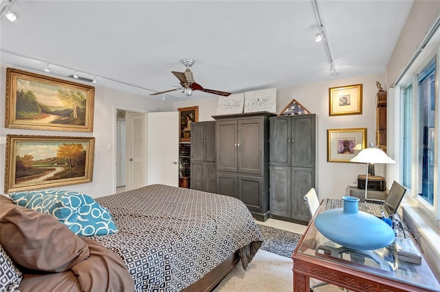 bedroom featuring light carpet, rail lighting, and ceiling fan