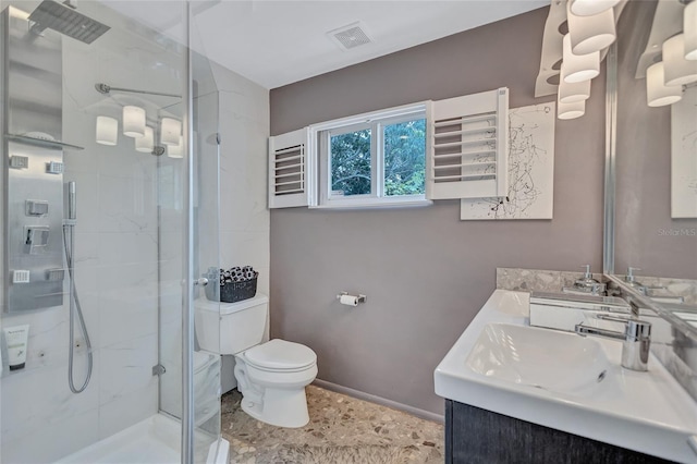 bathroom featuring a shower with door, vanity, and toilet