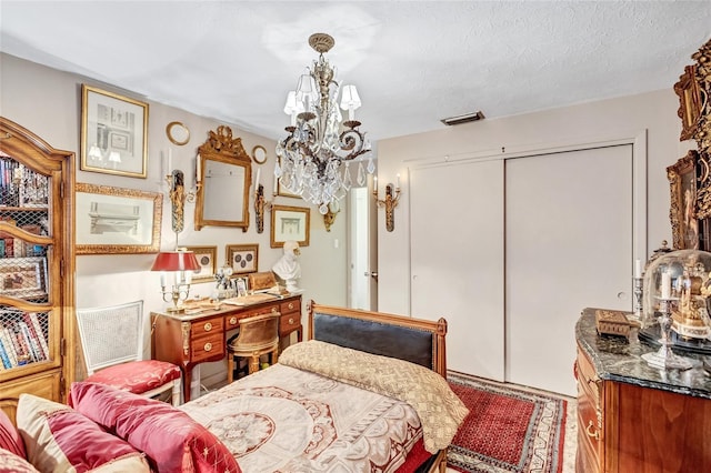 bedroom with a notable chandelier, a textured ceiling, and a closet