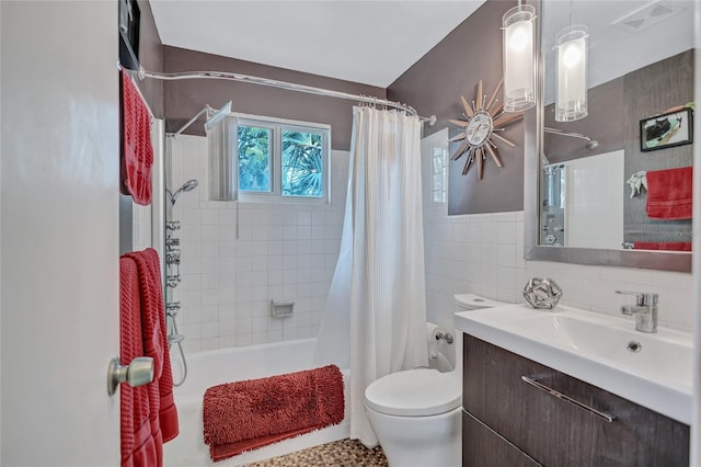 full bathroom with vanity, tile walls, shower / tub combo with curtain, and toilet