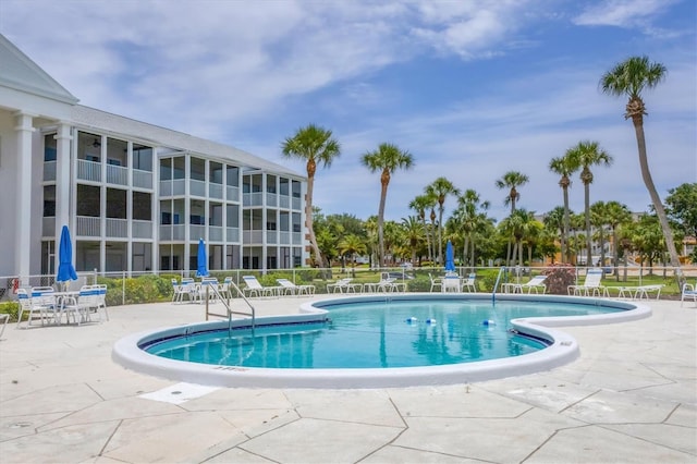 community pool featuring a patio and fence