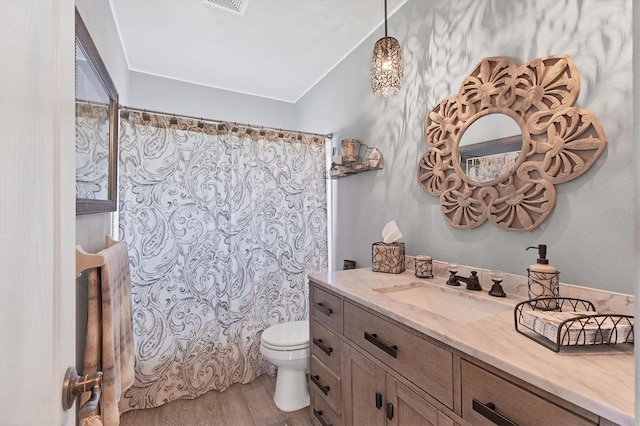 full bathroom with visible vents, toilet, wood finished floors, curtained shower, and vanity